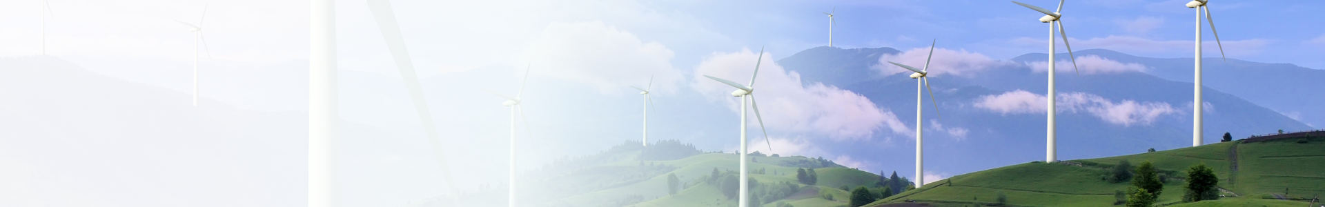 Panoramic banner image of wind turbines on green hills with mountains and clouds in the background.