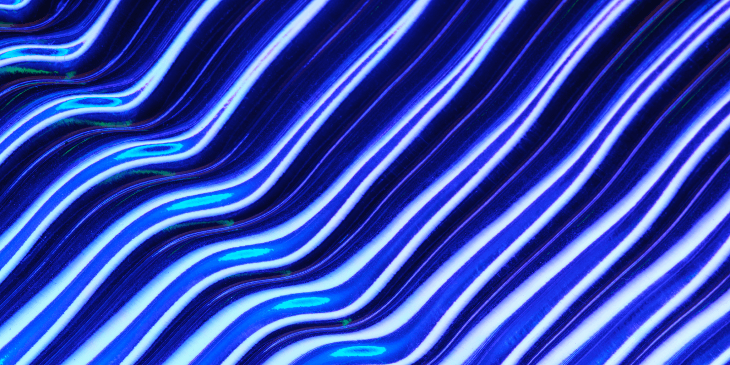 An abstract blue and white wavy line texture pattern, resembling flowing waves or light streaks. Used as a background or texture visual.