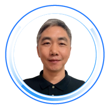 Portrait profile photo of an individual with short gray hair, wearing a black collared shirt, shown inside a circular blue digital frame.